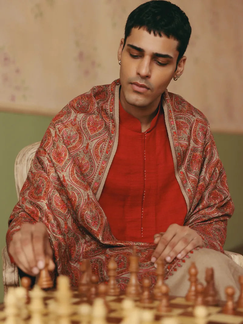 A man wearing a patterned shawl